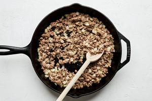 ground beef, garlic and onion being cooked in a skillet