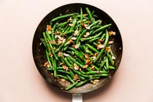 cooked green beans in a skillet with garlic and toasted almonds