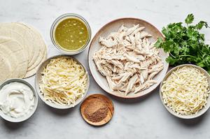 cheese, chicken, sour cream, green enchilada sauce, taco seasoning and cilantro in bowls for green chicken enchiladas