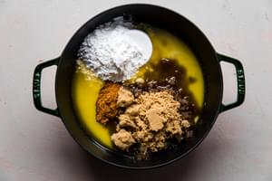 ingredients bring added to melted butter in a pot for hot buttered rum batter