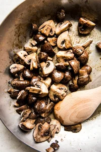 Dry Sauté Mushrooms in a pan with a wooden spoon