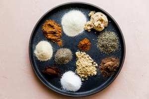 plate with small piles of dry spices for homemade jamaican jerk spice blend