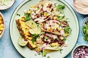 jerk chicken tacos topped with onion, pineapple, cabbage, cilantro and jerk aioli. served with a wedge of grilled pineapple