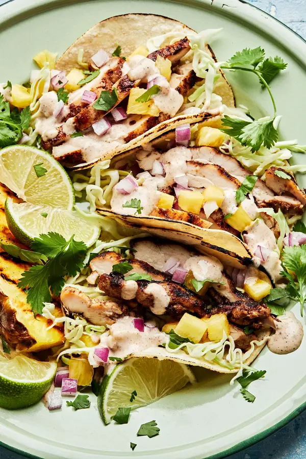 jerk chicken tacos topped with onion, pineapple, cabbage, cilantro and jerk aioli. served with a wedge of grilled pineapple