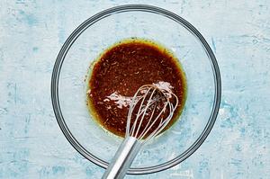 olive oil, jerk seasoning and lime juice being whisked together in a glass bowl