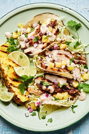 jerk chicken tacos topped with onion, pineapple, cabbage, cilantro and jerk aioli. served with a wedge of grilled pineapple