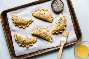 raw Keto Homemade pizza pocket on parchment with pastry brush