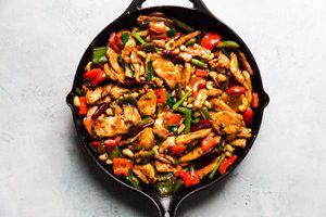 better than takeout homemade kung pao chicken in a skillet made with bell peppers, cashews and a savory sauce