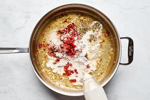 garlic, heavy cream, chicken stock, bouillon, Parmesan, sun-dried tomatoes, Italian seasoning and pepper in a skillet