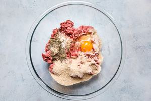 ground beef, seasonings, egg, bread crumbs, Worcestershire sauce and whole milk in a glass bowl for home made meatballs