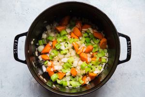 onions, celery, carrots and garlic cooked in olive oil in a pot for meatball stew
