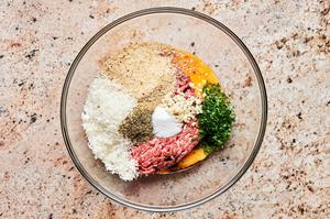 ground beef, egg, Worcestershire, breadcrumbs, parsley, parmesan, garlic and spices in a glass bowl to make meatballs