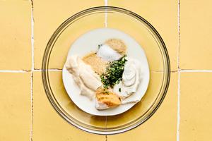 buttermilk, mayonnaise, sour cream, cilantro, onion powder, garlic powder, miso, and salt being mixed together in a bowl