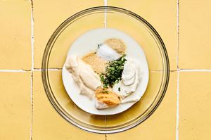 buttermilk, mayonnaise, sour cream, cilantro, onion powder, garlic powder, miso, and salt being mixed together in a bowl