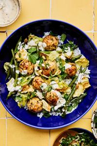 Chicken meatballs served on top of white rice, roasted green beans and cabbage and drizzled with miso ranch sauce