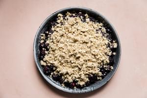 unbaked mixed berry crisp with oat topping in a baking dish