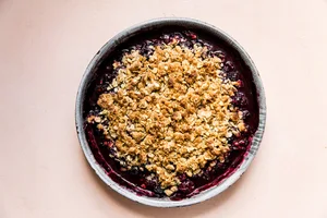 mixed berry crisp with oat topping in a baking dish fresh out of the oven