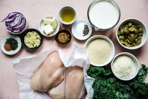 ingredients for one pot chicken with creamed kale in bowls on the counter including chicken, Kale, cream, Parmesan and panko