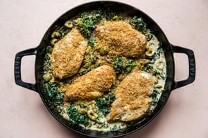 one-pot chicken with creamed kale topped with Castelvetrano  olives and toasted panko breadcrumbs in a skillet on the counter
