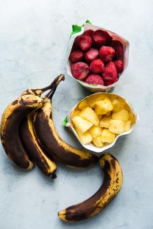 frozen bananas, frozen strawberries and frozen pineapple on the counter