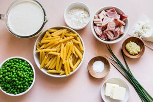 ingredients laid out for Pasta With Peas Pancetta And Goat Cheese garlic, cream, chives, salt
