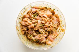 chicken marinating in peanut sauce in a bowl
