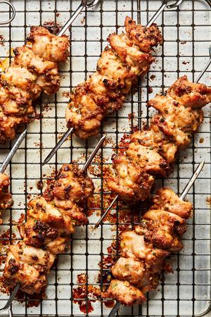 Peanut Sauce Marinated Chicken Skewers on a cooling rack on top of a baking sheet