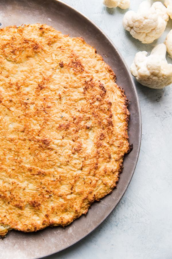 cauliflower pizza crust on a baking sheet