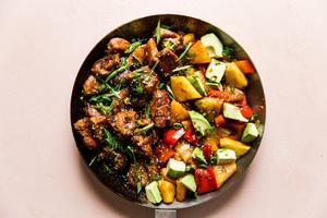 Pineapple Pork Stir Fry with red bell peppers and avocado in a skillet
