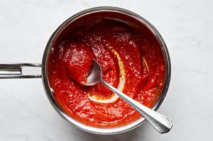 Pizza sauce warming in a sauce pan on the stove