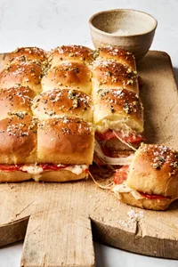 pizza sliders made with cheese and pepperoni with the tops brushed with butter, garlic, oregano and basil