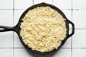 monterey cheese on top of chorizo and green chilis in a skillet