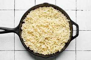 monterey cheese on top of chorizo and green chilis in a skillet