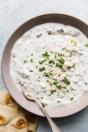 raita in a ceramic bowl with a spoon