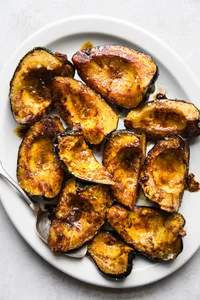 Roasted acorn squash halves seasoned with butter, brown sugar, salt, chili powder, and cumin, baked to golden perfection.