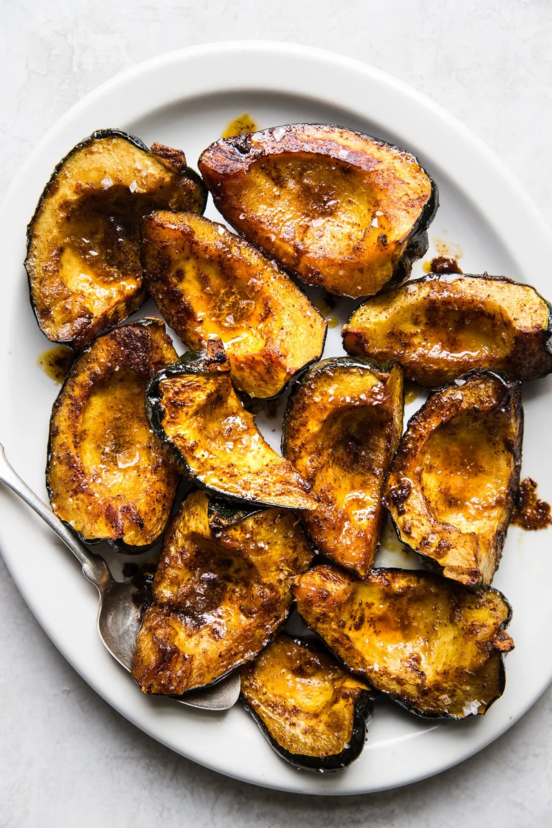 Roasted acorn squash halves seasoned with butter, brown sugar, salt, chili powder, and cumin, baked to golden perfection.