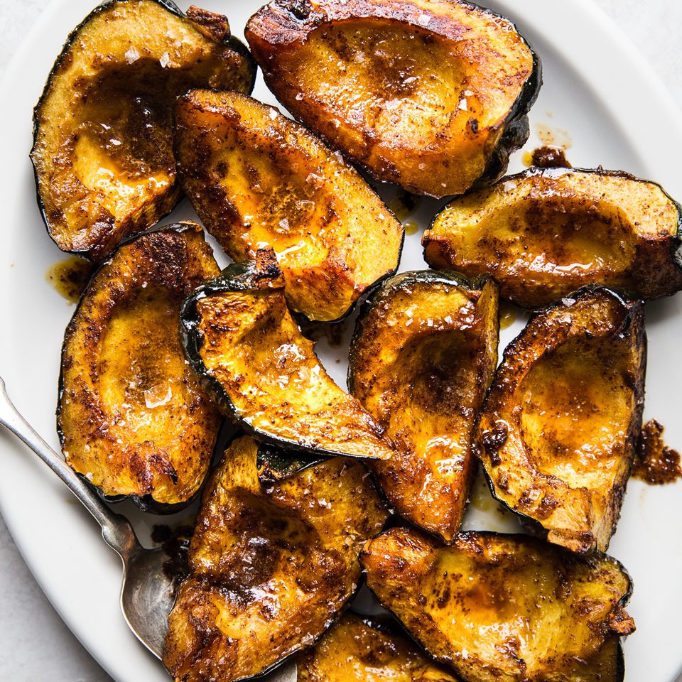 Roasted acorn squash halves seasoned with butter, brown sugar, salt, chili powder, and cumin, baked to golden perfection.