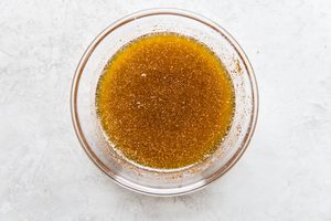 melted butter with chili powder, brown sugar, cumin and salt in a glass bowl to baste on acorn squash