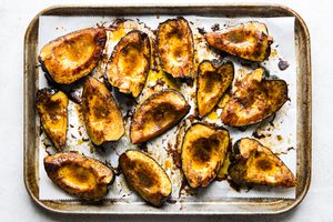 Roasted acorn squash halves seasoned with butter, brown sugar, salt, chili powder, and cumin, baked to golden perfection.