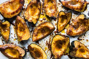 Roasted acorn squash halves seasoned with butter, brown sugar, salt, chili powder, and cumin, baked to golden perfection.