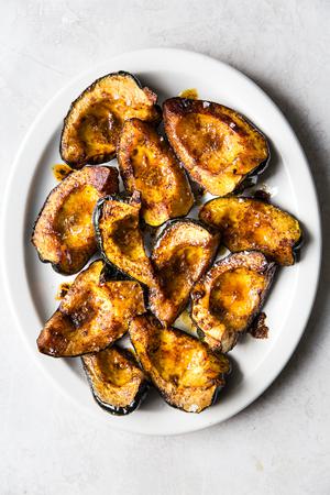 quartered roasted acorn squash on a white platter