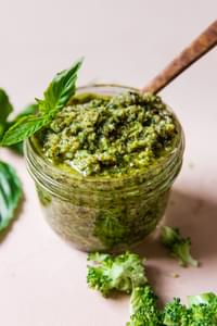 roasted broccoli pesto in a jar topped with fresh basil