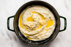 pot of roasted garlic mashed potatoes topped with melted butter and black pepper