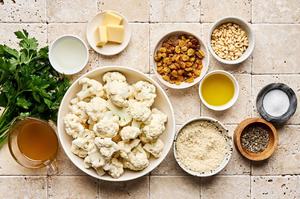 cauliflower, olive oil, spices, pine nuts, butter, panko, golden raisins, chicken stock and white wine vinegar in bowls