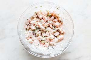 ingredients for shrimp melt mixed together in a glass . bowl