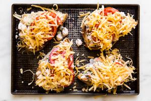 shrimp melts topped with grated cheese on a baking sheet