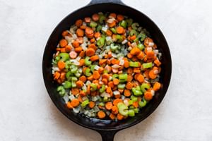 butter, carrots, onion and celery sautéed in a cast iron skillet