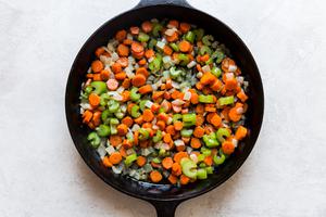 butter, carrots, onion and celery sautéed in a cast iron skillet