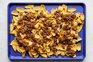 sloppy joe ground beef on top of fritos on a baking sheet