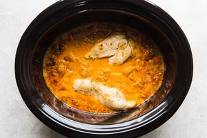 pumpkin curry in a slow cooker with whole cooked chicken breasts
